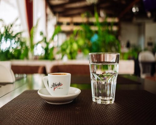 A cup of local coffee next to a glass of water